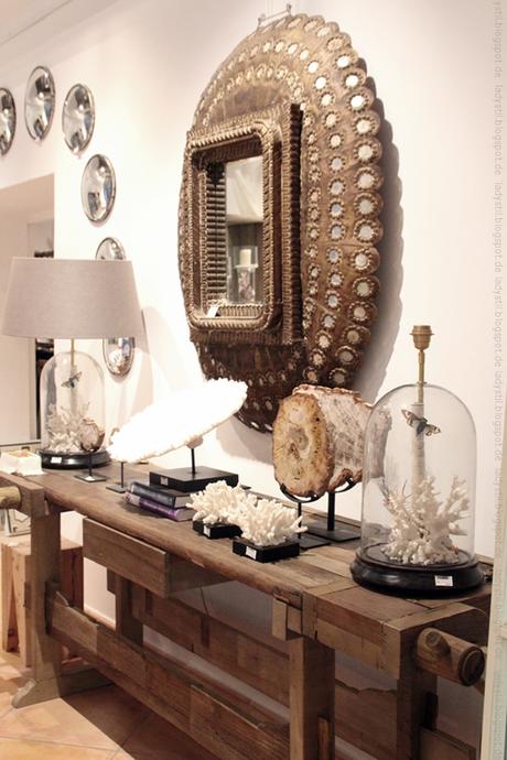Holzkommode mit diversen Wohnaccessoires und einem riesigen runden Spiegel darüber im Geschäft Bondian Living in Palma