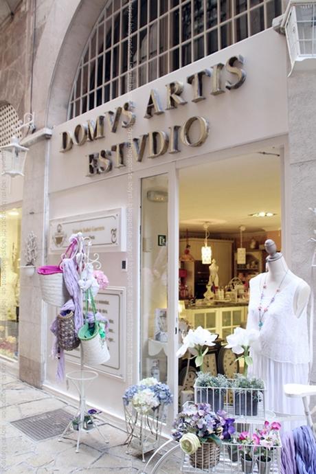Blickk auf den Eingang des Interior Geschäfts Artis Domvs in Palma mit Ständer voller Korbtaschen 