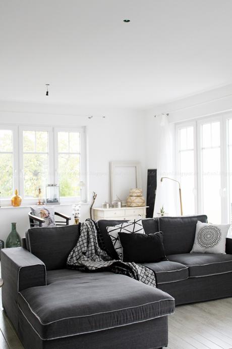Gesamteindruck des Wohnzimmers Blick auf das Sofa, Kommode und diverse Wohnaccessoires