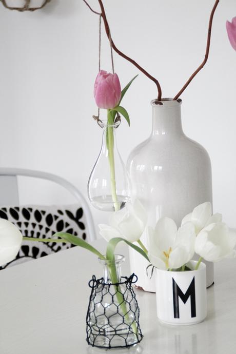 Glasvasen zum Aufhängen mit Sammelsurium an Gefäßen und Tulpen
