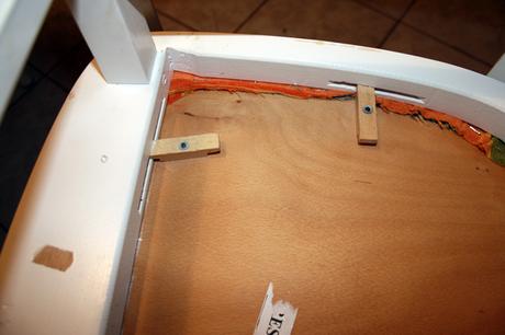 Dieses Stuhlpolster hält per drehbaren Holzstäbchen. Bei anderen Stühlen muss man oft ein paar Schrauben lösen. 