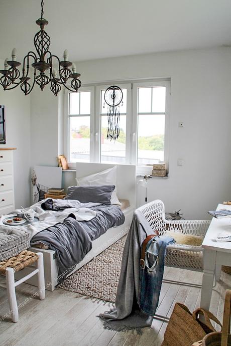 Schlafzimmer mit kuscheligen Decken aus natürlichen Materialien in grau weiß schwarz