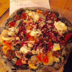 Pizza mit Fleisch und Gemüse auf einem Weizen-Sepia Boden