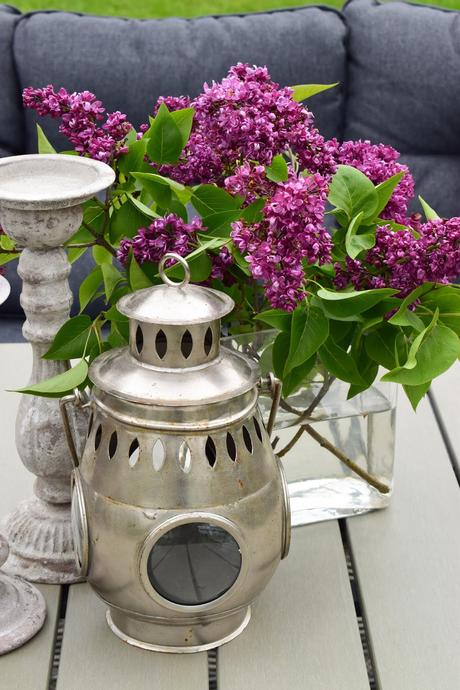 Deko mit Flieder für deinen Gartentisch. Dekoidee Garten Outdoor Möbel mit Flieder Laterne Kerzenständer. Naturdeko