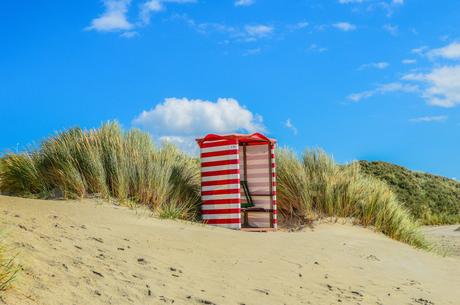 Wassertemperatur Borkum: Roter Strandkorb auf Sanddüne mit Gras unter blauem Himmel auf Borkum Wassertemperatur Borkum: Roter Strandkorb auf Sanddüne mit Gras unter blauem Himmel auf Borkum