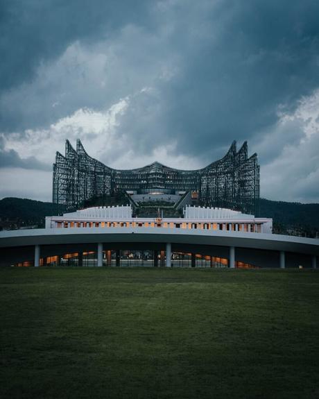 Nusantara 2025: Unsere Reise in Indonesiens neue Hauptstadt Modernes Gebäude mit geschichtetem Design vor einem wolkigen Himmel, umgeben von üppigem Grün und einem großen Rasen, der an die ruhigen Landschaften von Nusantara erinnert.