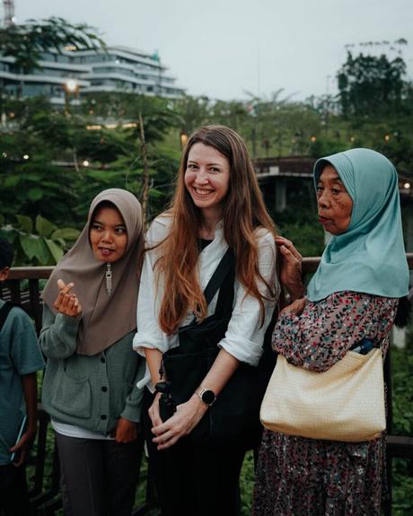 Nusantara 2025: Unsere Reise in Indonesiens neue Hauptstadt Drei Frauen stehen zusammen draußen, mit dem üppigen Grün und den traditionellen Gebäuden von Nusantara im Hintergrund.