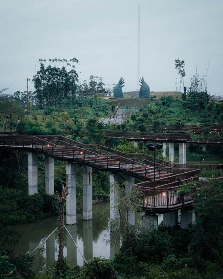 Nusantara 2025: Unsere Reise in Indonesiens neue Hauptstadt Erhöhter Holzsteg im üppigen Nusantara-Park mit großen Vogelskulpturen und einem hohen Turm im Hintergrund.