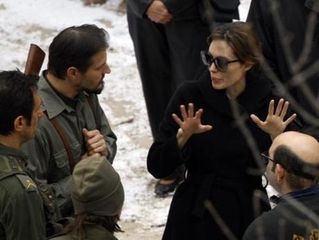 Actress Angelina Jolie (R) talks to actors during the filming of her yet untitled directorial debut in Budapest November 8, 2010. Jolie is directing her first feature film about a Serbian man and Bosnian woman who meet on the eve of the 1992-95 Bosnian war. REUTERS/Laszlo Balogh (HUNGARY - Tags: ENTERTAINMENT)