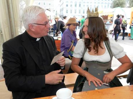Die Heukönigin schreibt dem Erzbischof eine persönliche Widmung und überreicht ihm ihre Autogrammkarte
