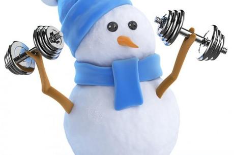 Ein kleiner Schneemann hebt zwei kleine Gewichte um fit für den Winter zu werden