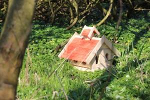 Vogelhaus aus Holz mit roten Holzschindeln