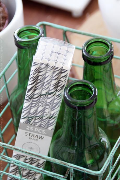 Drei grüne Flaschen im Korb mit Strohhalmen Zebra black white