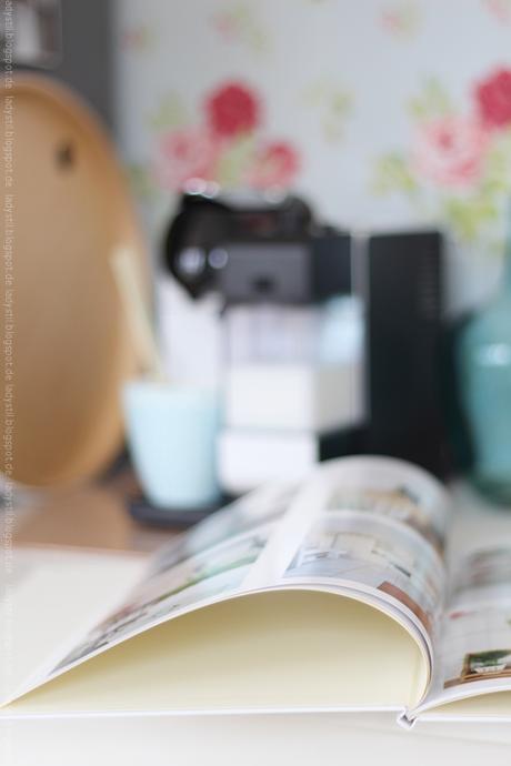 Blick auf ein Fotobuch im Hintergrund verschwommen die Kaffeemaschine