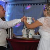 Brautpaar schneidet Hochzeitstorte an