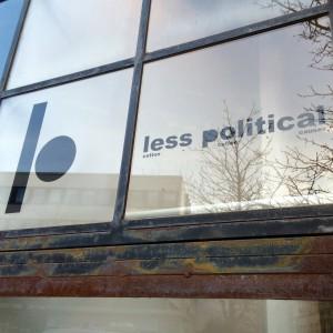 Logo und Less Political Schriftzug auf einem Fenster