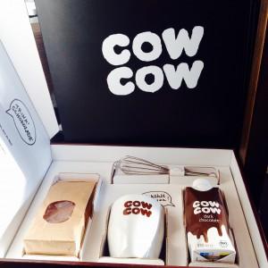 Box mit cow cow Becher, Trinkschokolade, Schneebesen und Schokolade