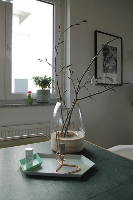 Zweige in einer grossen Vase mit weissem Weihnachtsstern mit HAY Tablett und HAY Kupferkerzenständer und Marmor Ikea Salzstreuer