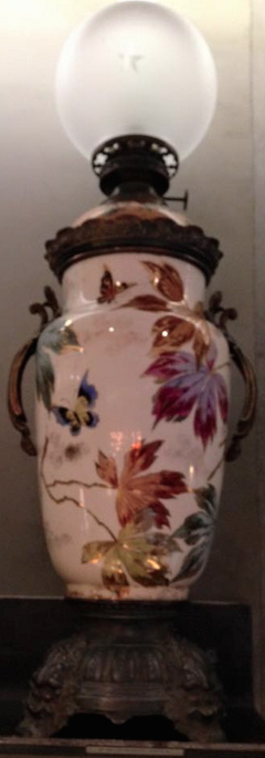 Von Hand bemaltes Blumen-Dekor schmückt diese Öllampe.