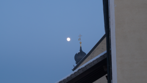 Die Zwiebelspitze der Veitskapelle vor dem aufgehenden Mond.
