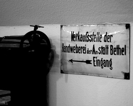 Blog + Fotografie | fim.works | Nachtansichten Bielefeld | Anstalt Bethel | Ausstellung BroSa | Hinweisschild Verkaufsstelle Handweberei 