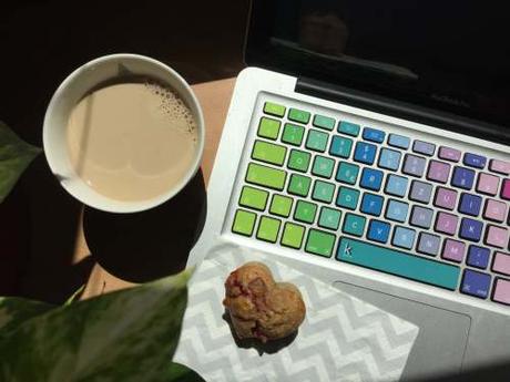 Kaffee und Muffin, neben bunter Macbook Tastatur