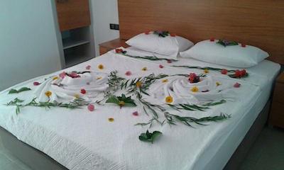 Mit Liebe zum Detail wird das Bett mit Blumen für Frisch Verheiratete dekoriert.
