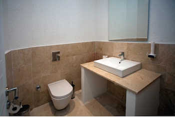 Der Toilettenbereich ist vom eigentlich Badezimmer getrennt.