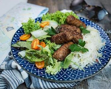 Klassische Cevapcici auf buntem Salat