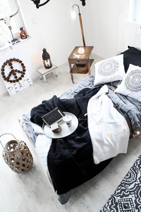 Schlafzimmerdeko im New Boho Look mit schwarz-weißen Ethnoelementen und Holz Accessoires, Bohoschädel, afrikanische Maske und Bambus-Laterne