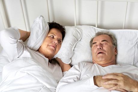 Senioren im Bett, Mann schnarcht, Frau ist genervt