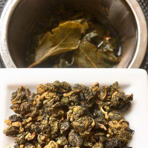 Oolong Tee in Kügelchen und als Blätter nach dem Aufguss 