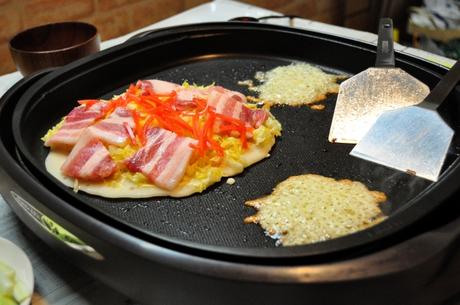 Okonomiyaki Bei Okonomiyaki nach Hiroshima Style kommen alle Zutaten auf den Teig.