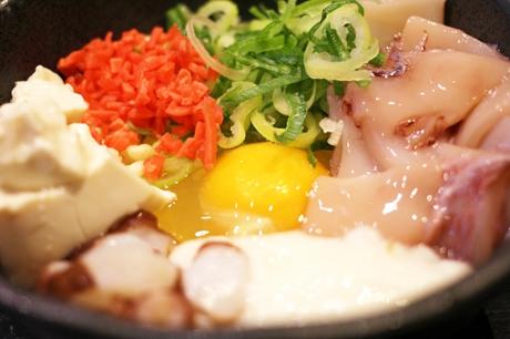Okonomiyaki Im japanischen Restaurant erhält man Teig und Zutaten zusammen in einer Schüssel zum Selberkochen.