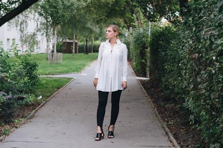 BlackAndWhite Outfit in weißer Tunkia-Bluse von Lineight, Mini-Pochette von Louis Vuitton, Jeggings mit Fußschlaufen, Mules mit Goldabsatz und runder Sonnenbrille