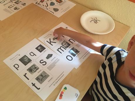 Kind spielt aus eigener Motivation heraus mit Buchstabenkarten und Großbuchstaben und Kleinbuchstaben zu lernen.