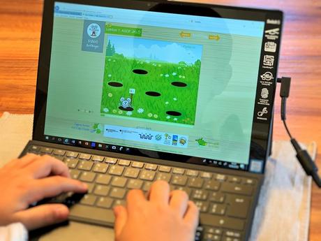 Kind lernt Tastatur Maschinen schreiben auf Tablet