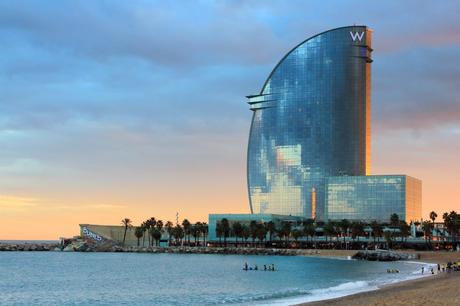 Wassertemperatur Barcelona: Hotel W mit Badestrand und Palmen bei Sonnenuntergang