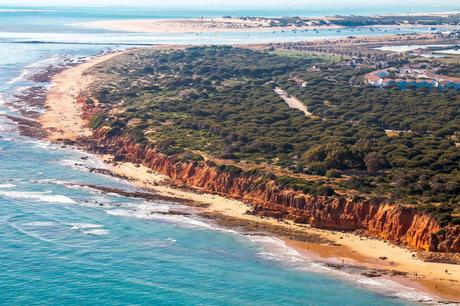Wassertemperatur Cadiz: Strand mit rötlicher Steilküste Playa Santi Petri bei Chiclana de la Frontera an der Mündung des Caño de Sancti Petri aus der Luft