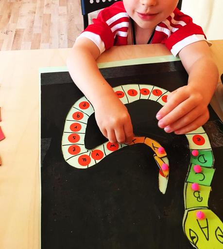 Selbstgebasteltes Buchstaben Puzzle Buchstaben Schlange Kind spielt mit Puzzle und legt die Großbuchstaben an die richtige Stelle