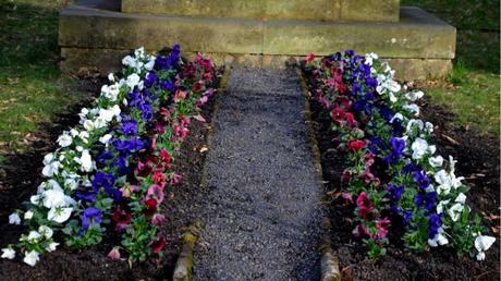 Grab mit Blumen und Steinen dekoriert 
