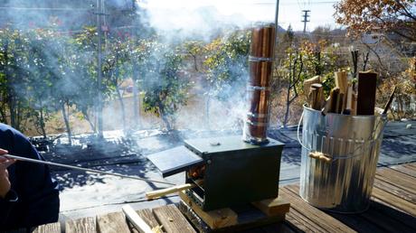 Mit Holz kocht es sich in der Outdoor Küche noch schönerg