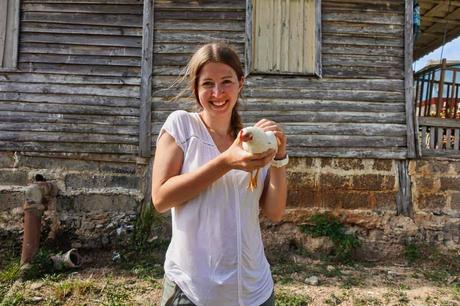 Eine Frau hat ein weißes Huhn in der Hand