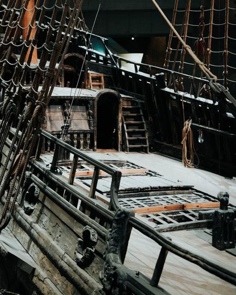 Das verwitterte Holzdeck und die Takelage eines alten Segelschiffs, das in einem Museum ausgestellt ist.