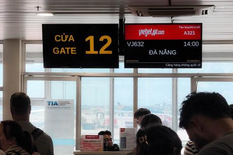 Menschen warten am Flugsteig 12 auf den VietJet Air Flug VJ632 nach Da Nang, der um 14:00 Uhr startet.