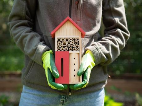 Eine Person hält ein gekauftes Insektenhotel in die Kamera.