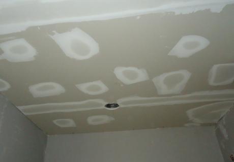 Verspachtelte Schraubstellen an einer Gipskartondecke vor dem Anstrich.