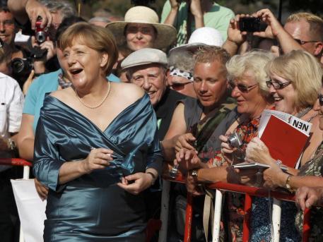 Lächelnd gibt Angela Merkel vor der Eröffnung der Bayreuther Festspiele Autogramme