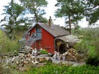 Rotes Gartenhaus mit Holzlager