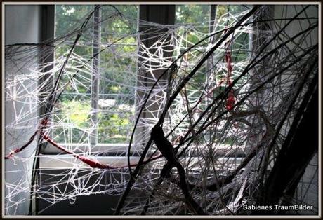 Installation eines Spinnennetzes aus Wollfäden auf einer Ausstellung